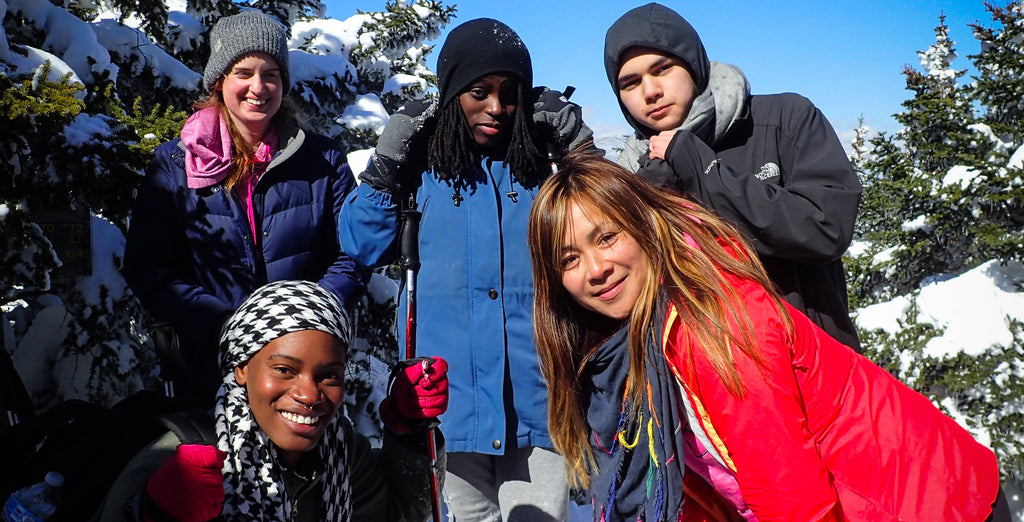 a group of hikers pose on a winter hike
