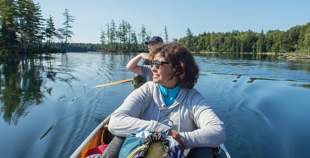 two people in a canoe from the front paddling on a adirondack lake