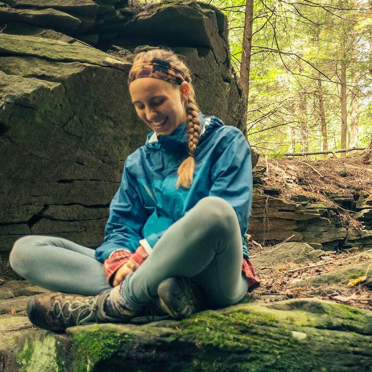 Person sitting on a rock in a forest