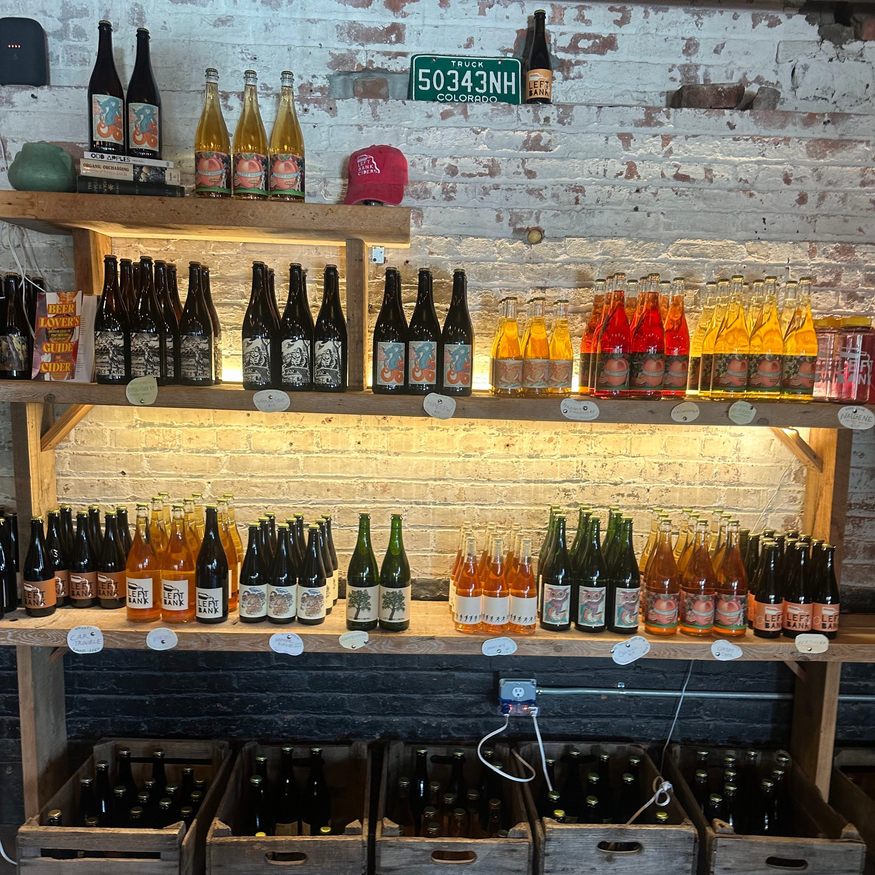 Shelf displaying various bottles of beer and drinks in a rustic setting.