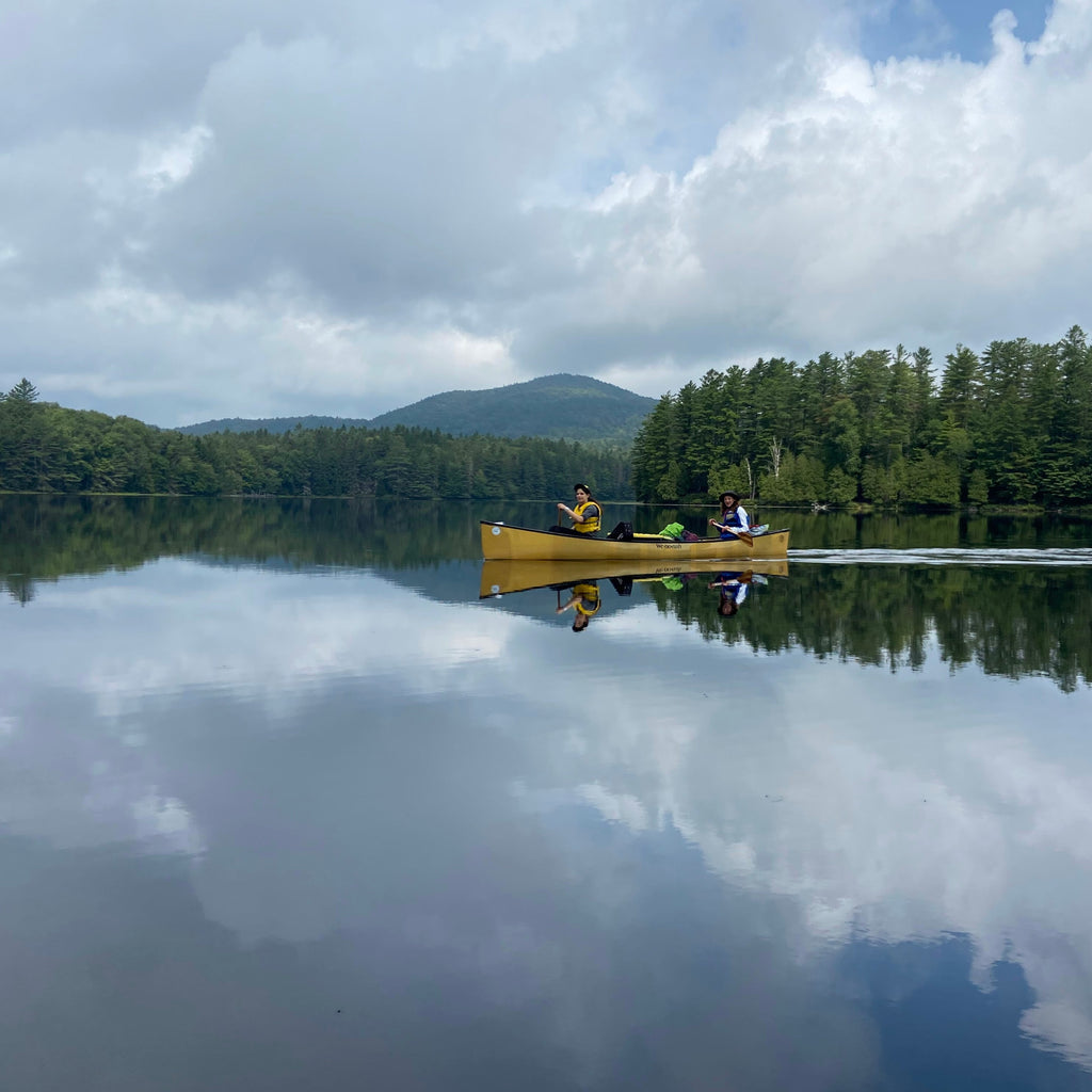 two people on a canoe in an adirondack lake