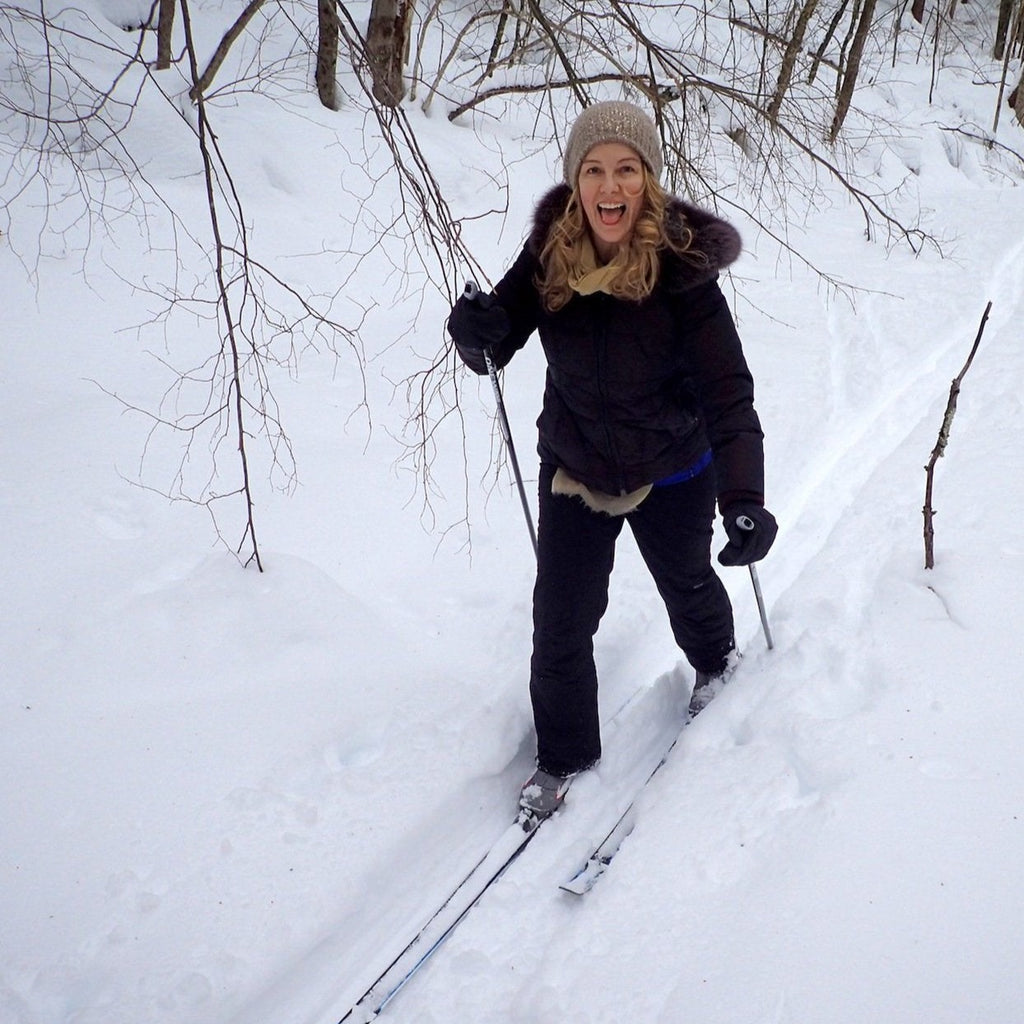 a cross country skier smiling on trail
